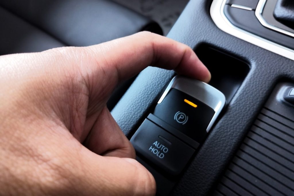 De bestuurder drukt op de elektronische parkeerrem